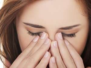 Image of a woman rubbing her eyes.