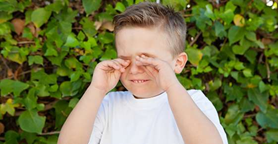 Image of a boy rubbing his eyes.
