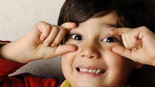 boy holding eyelids open with fingers