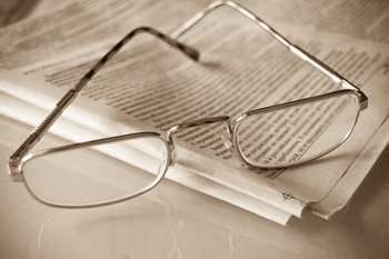 Image of glasses resting on a newspaper. 