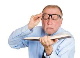 man reading with glasses pushed off face